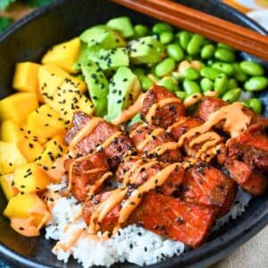 close up of a salmon poke bowl with chop sticks