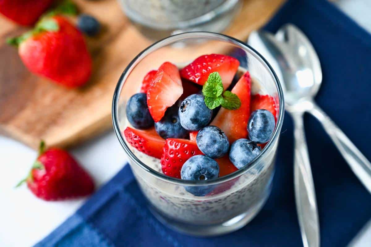 chia flax protein pudding in a glass on top of a napkin with two spoons