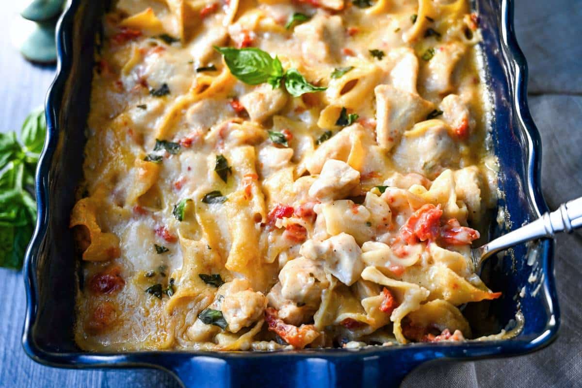 a baked chicken casserole with a serving spoon