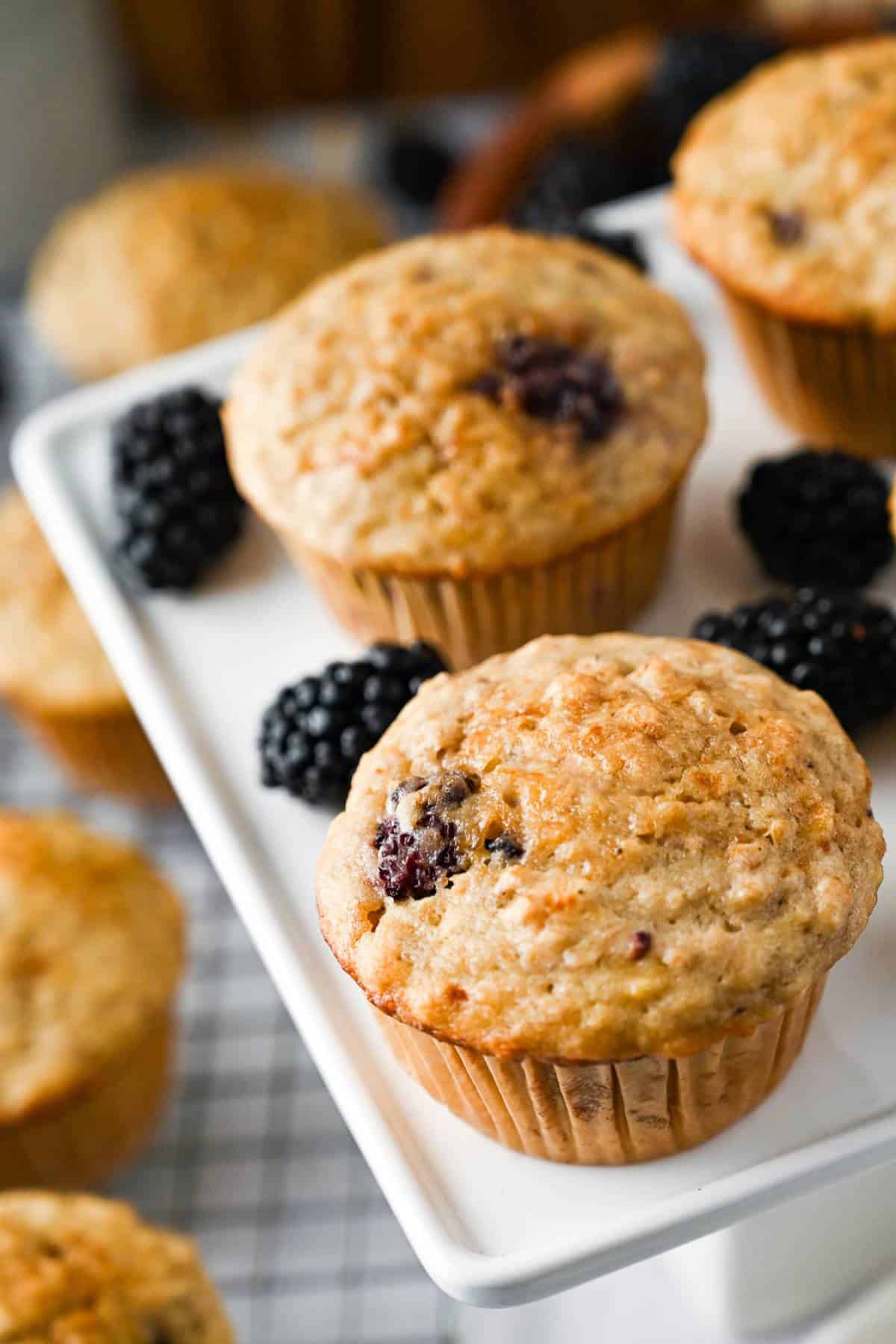 banana muffins on a platter with blackberries