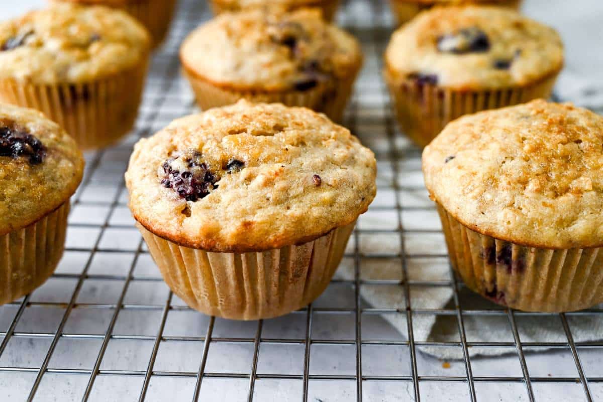 blackberry banana muffins in parchment liners on a cooling rack