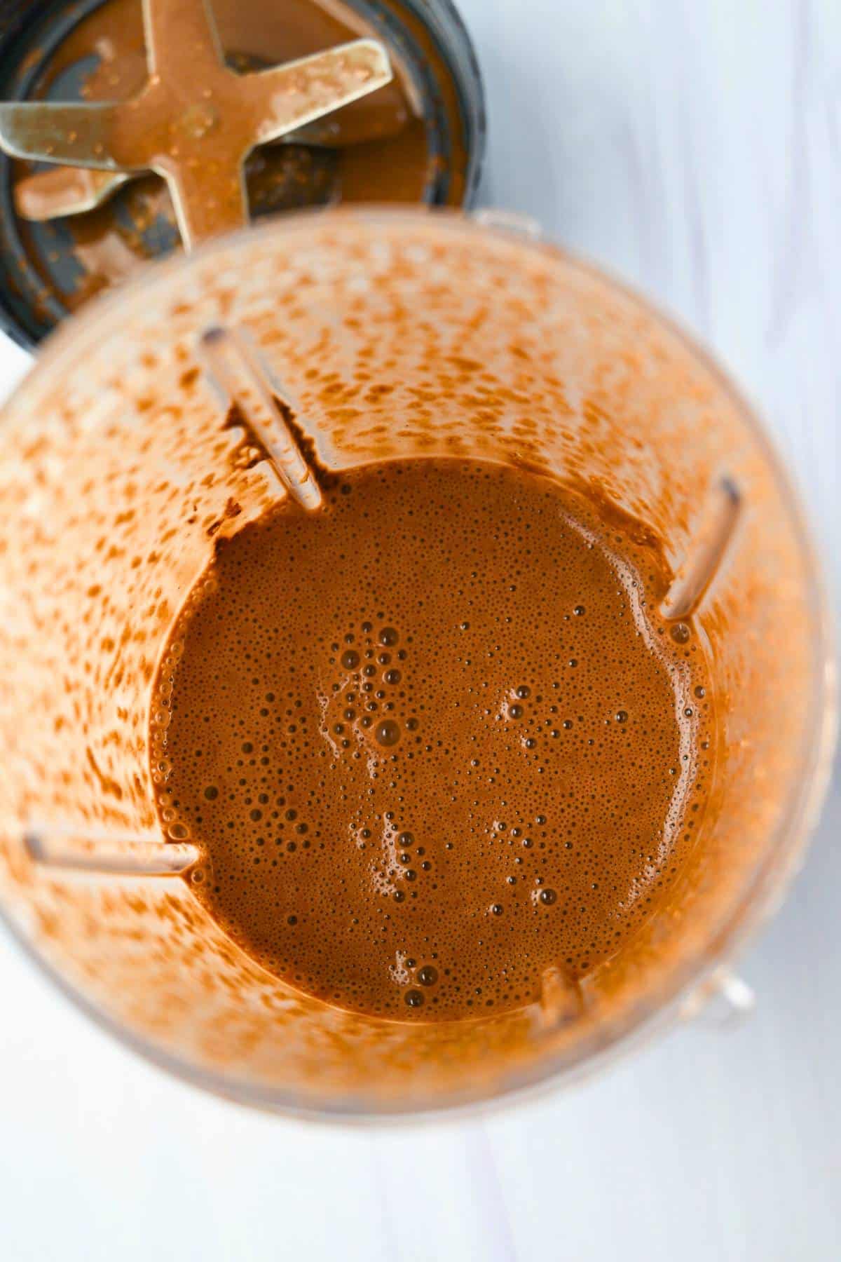 looking down into blended chocolate baked oats batter in a blender jar