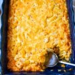 mac and cheese baked up close in the pan with a serving spoon