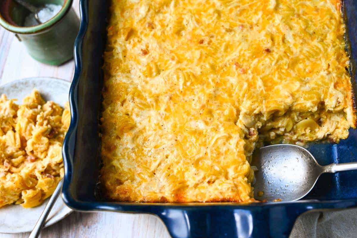 a plate of mac and cheese with a pan of protein packed chicken mac