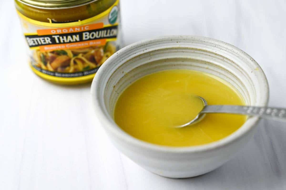 a jar of bouillon pasta and a dish of bouillon with a spoon