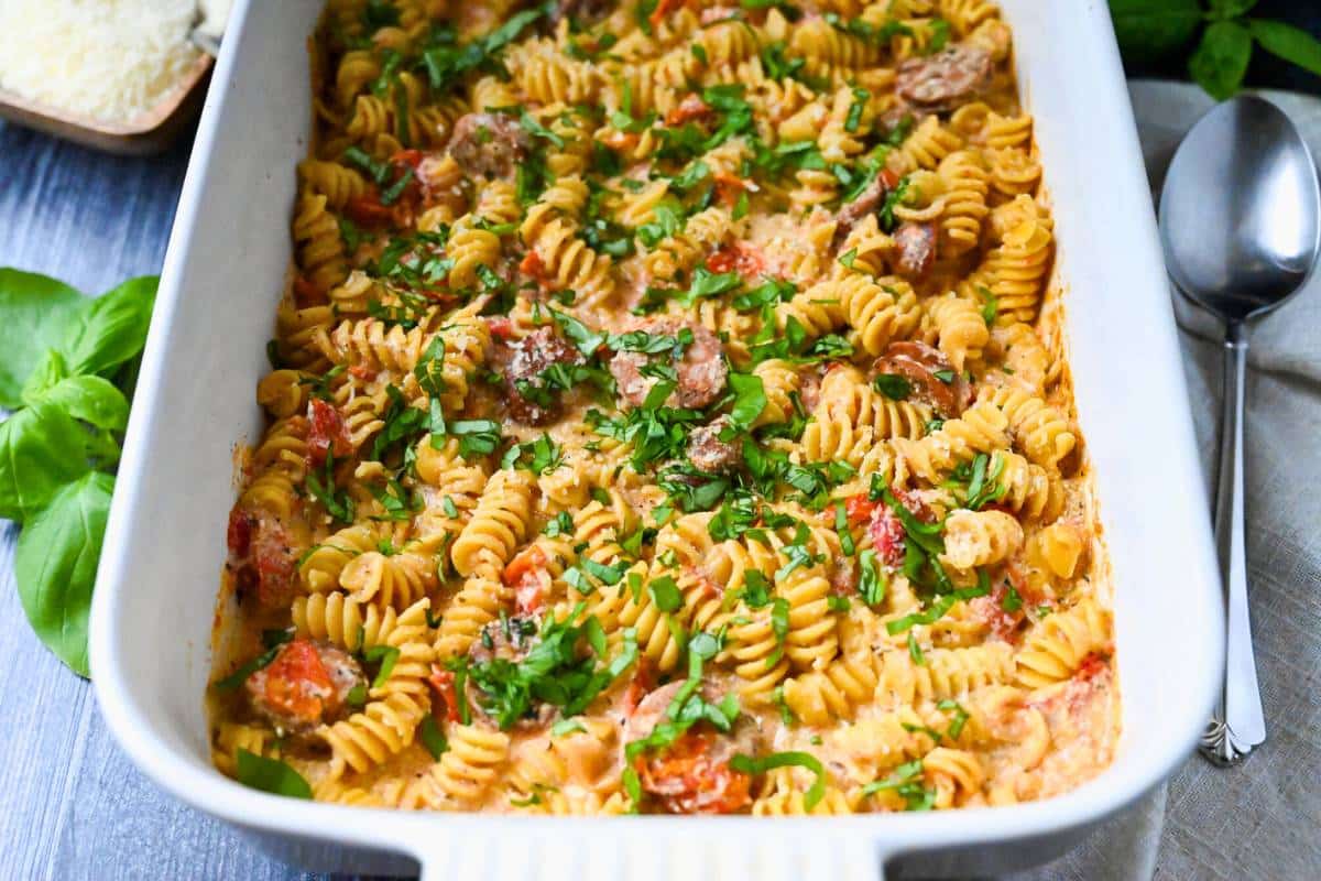 a pan of baked tomato boursin pasta with fresh basil on top