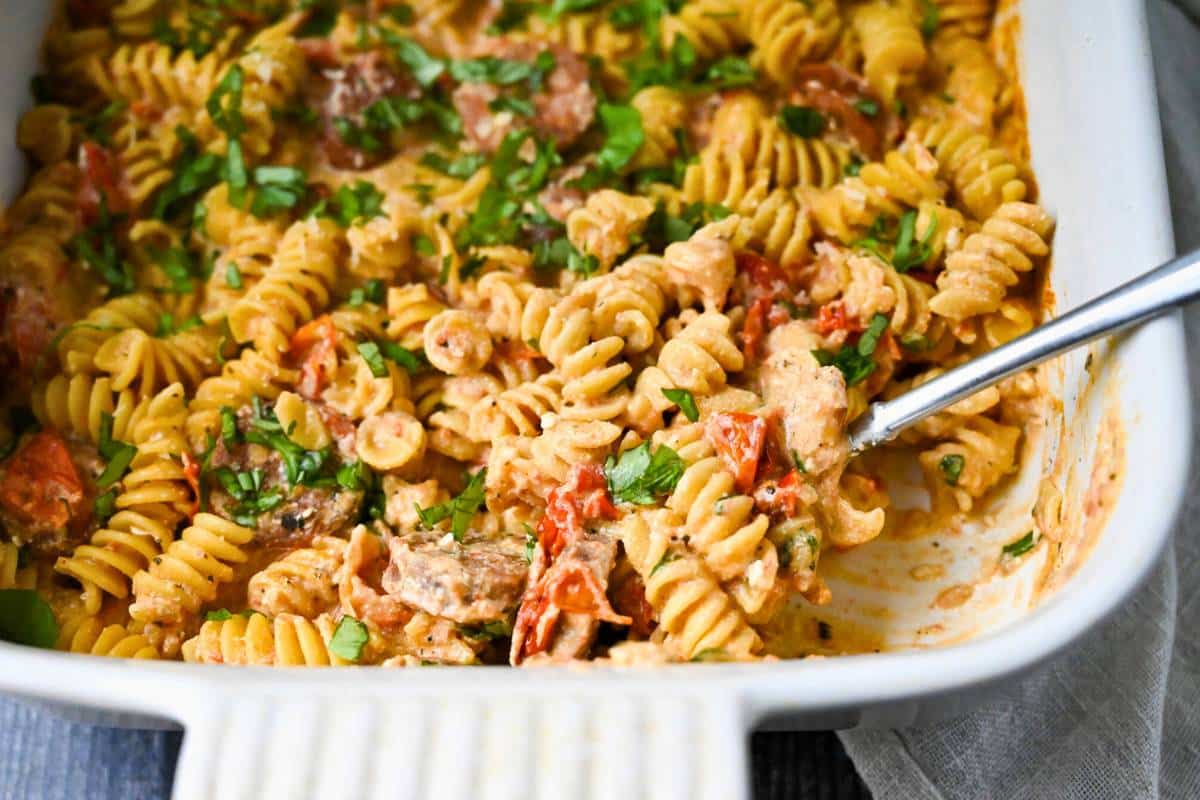 side view of a casserole dish with baked pasta with a spoon in it