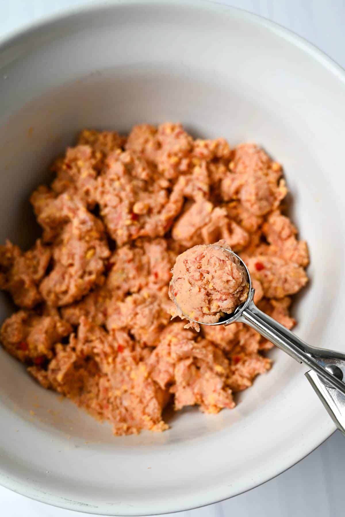 sausage ball mix in a bowl with a scoop of mix