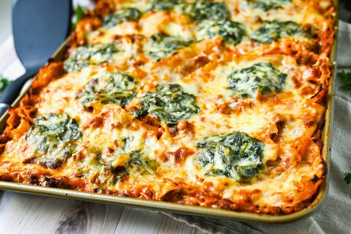 side view of a baked sheet pan lasagna with ground beef and spinach