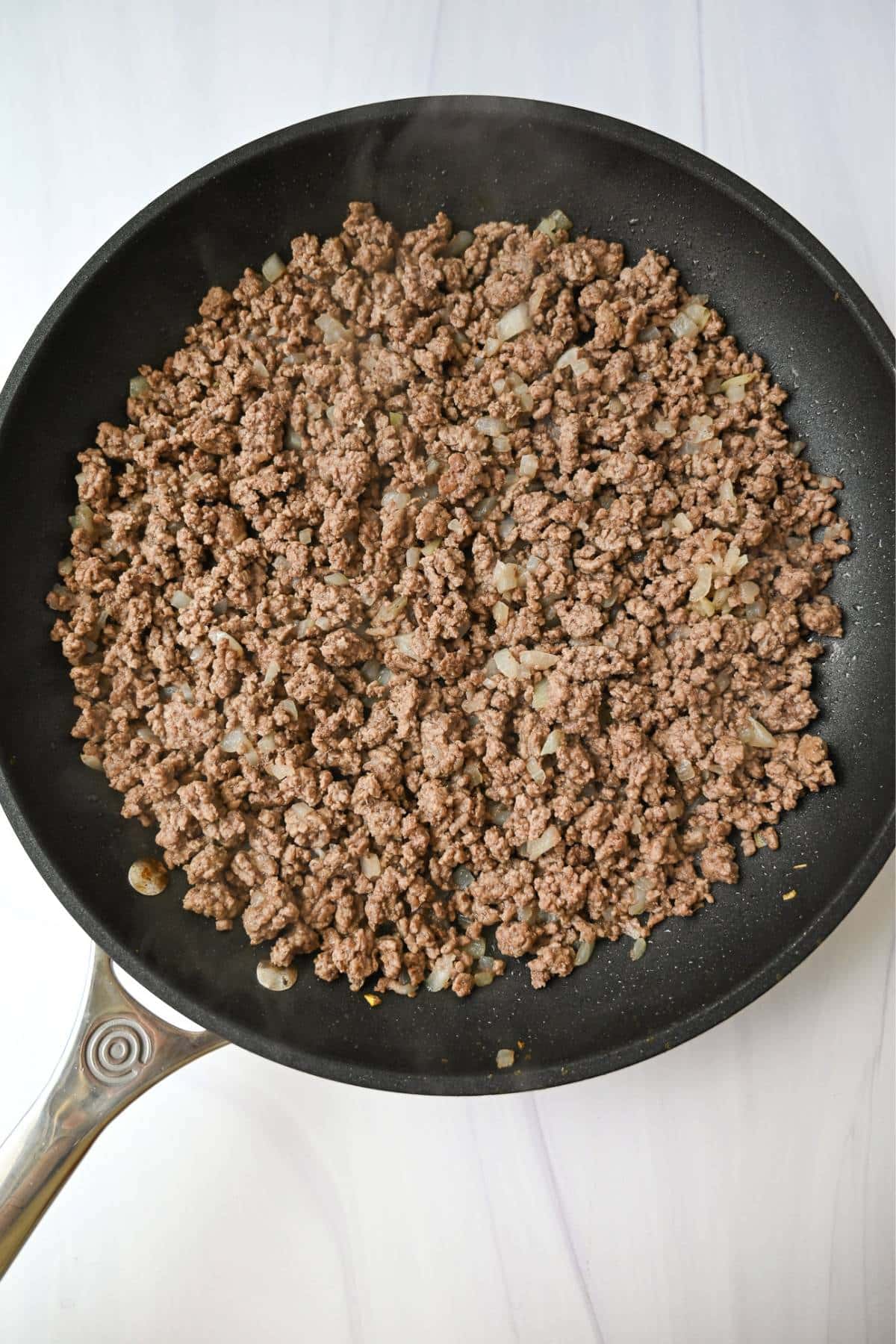 ground beef and onion cooked in a skillet