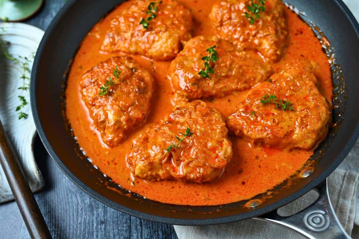 side view of a pan of cooked creamy paprika chicken breasts