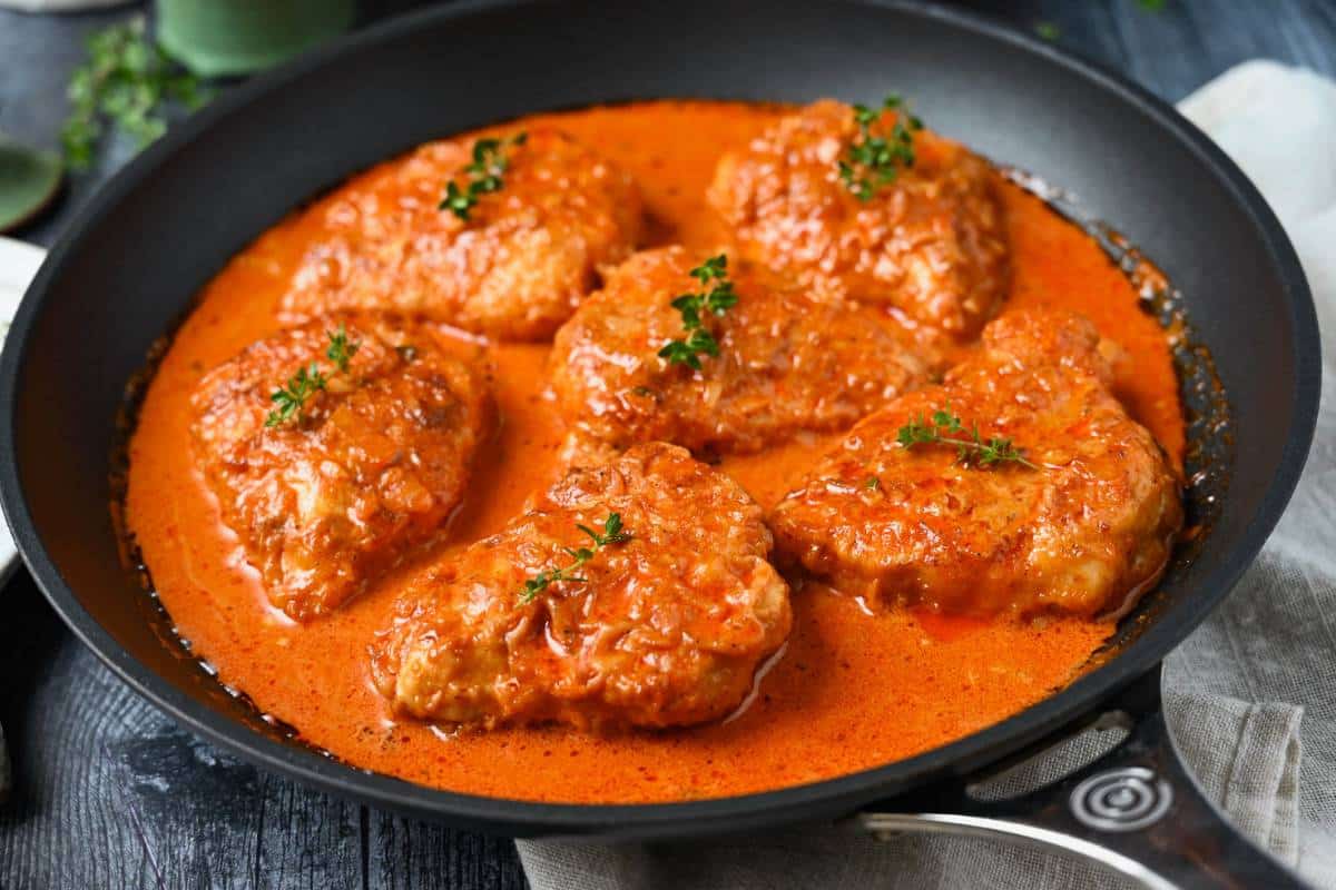 a skillet of chicken in paprika cream sauce
