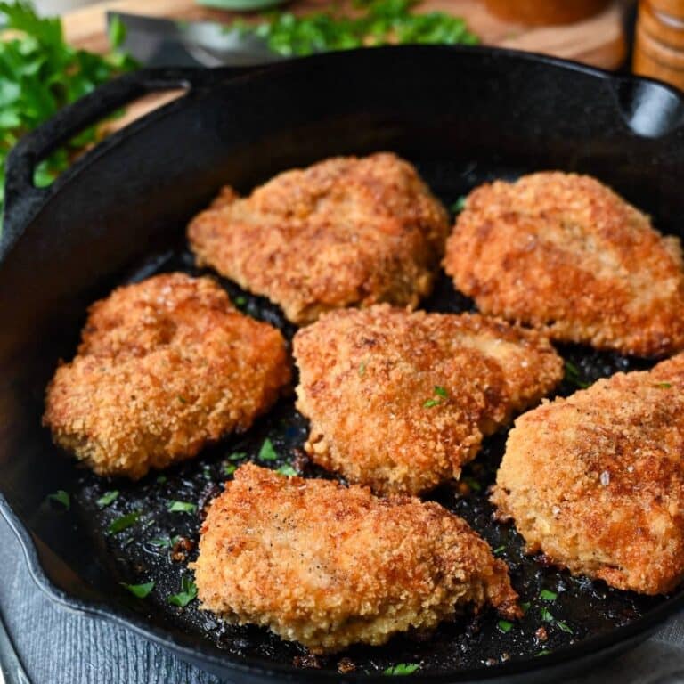 fried chicken in a cast iron skillet with parsley sprinkled on top