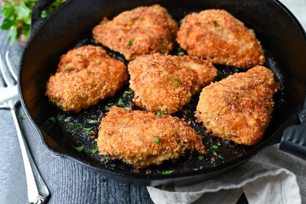 golden pan-fried and oven-finished fried chicken in a cast iron pan