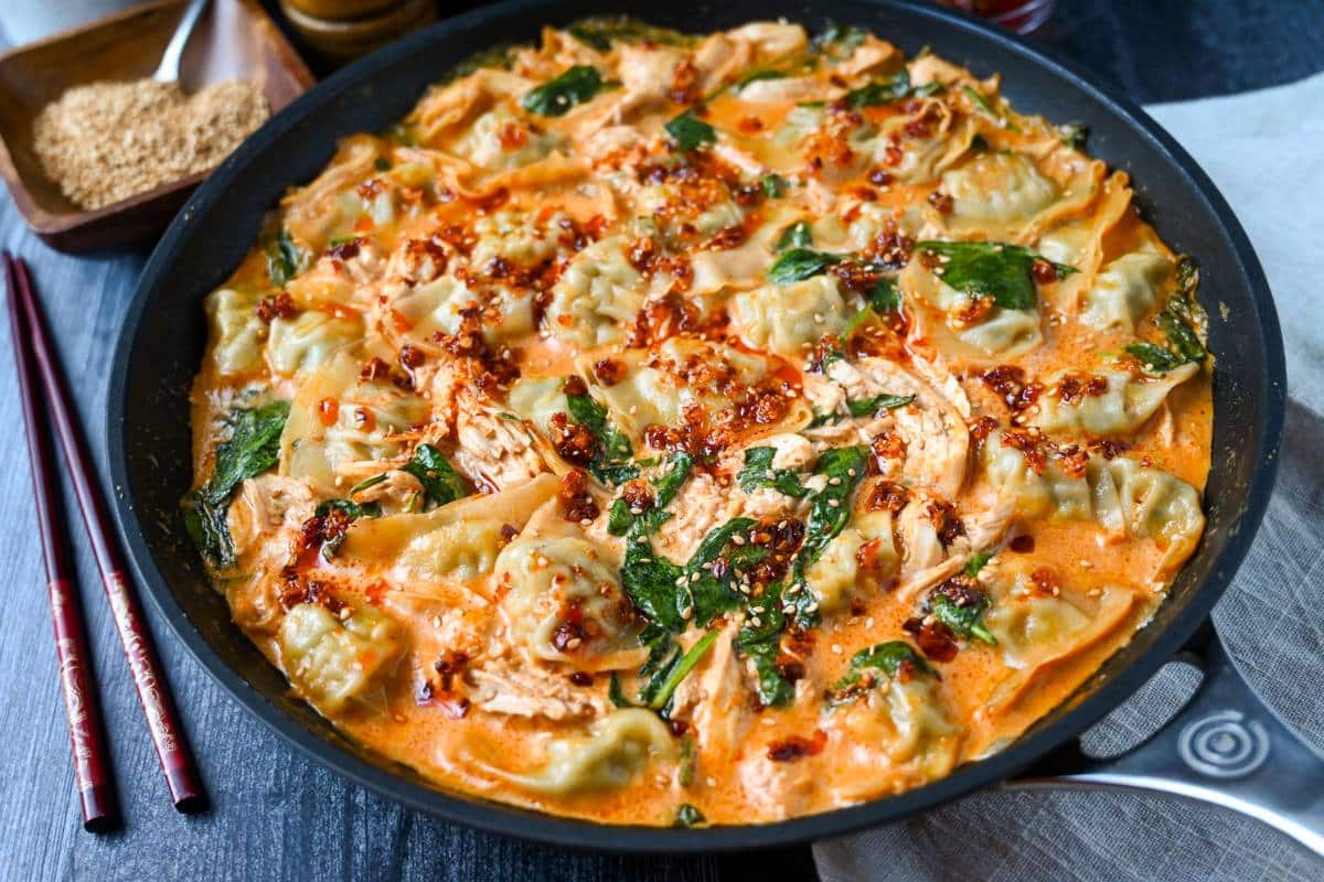 looking down at a dumpling with chicken bake with a bowl of roasted sesame seeds and chopsticks