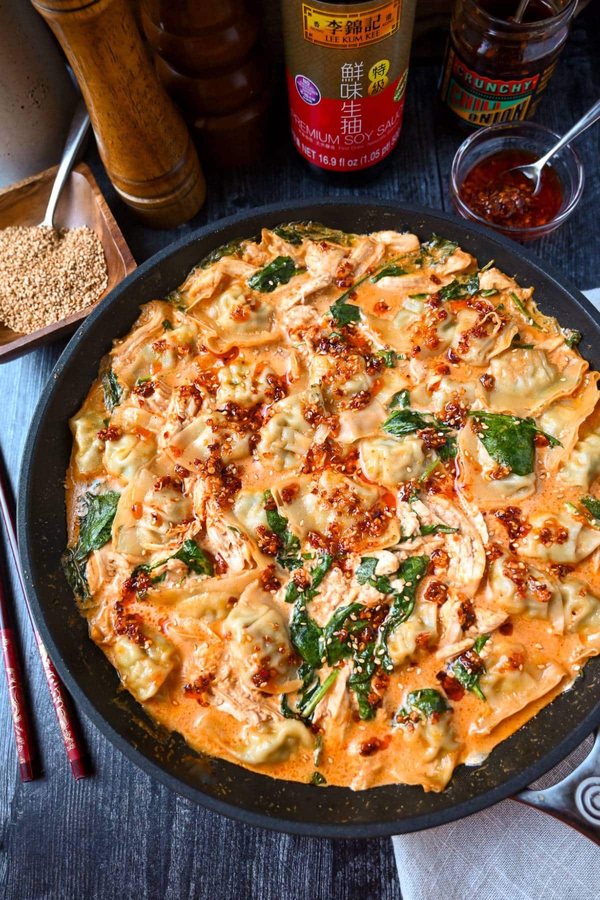 skillet with baked wonton dumplings, spinach and chicken