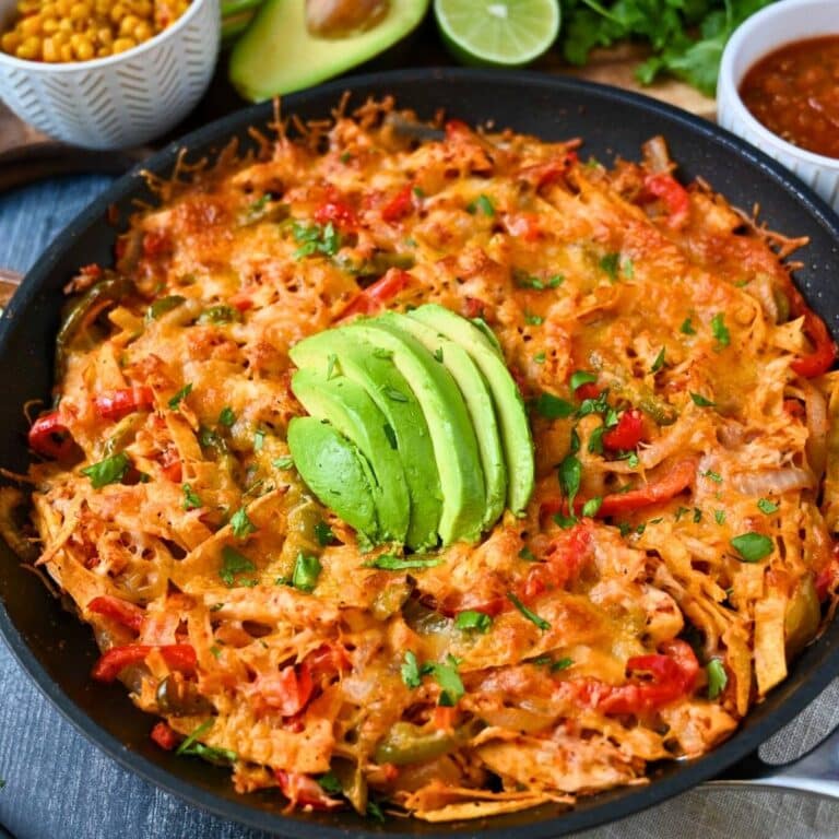 close up of a chicken fajita skillet with cheese and avocado on top