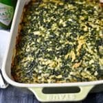 close up of a baked spinach casserole with chicken and cheese in a pan