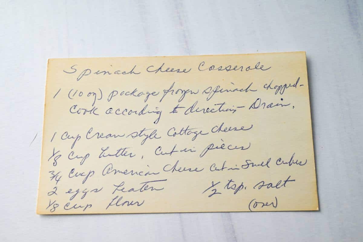 a family recipe for spinach casserole on a recipe card