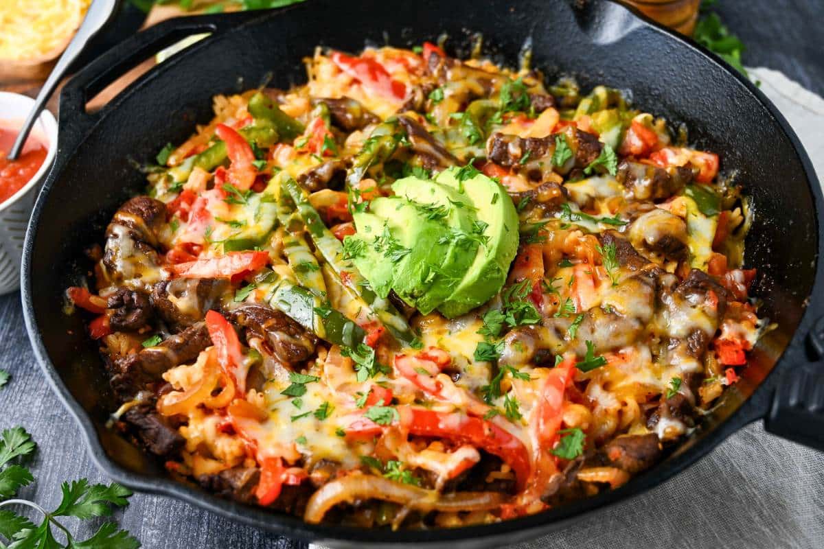 steak fajitas with rice and cheese in a skillet