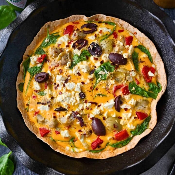 close up of a baked egg tortilla quiche with vegetables