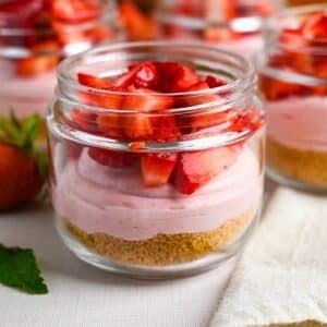 a zoomed in photo of a single serving high protein strawberry cheesecake parfait