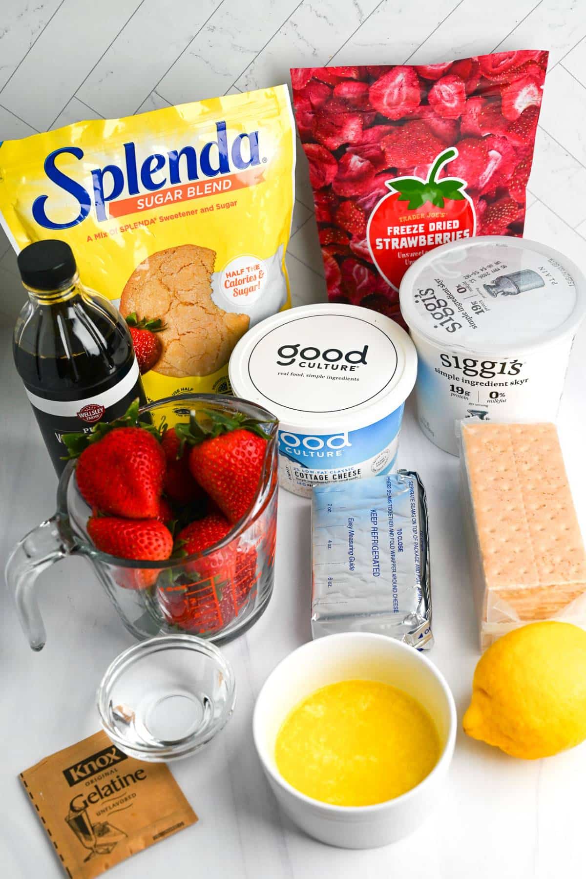 ingredients for high protein strawberry cheesecake dessert parfaits on a counter
