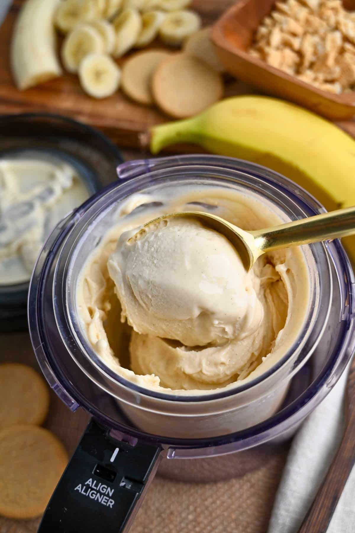 scooping out banana pudding ice cream from a creami pint container