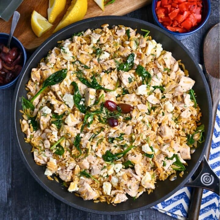 a chicken orzo skillet with fresh dill and olives on top