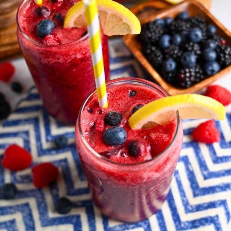 two glasses of sparkling berry lemonade with fresh berries and slices of lemon