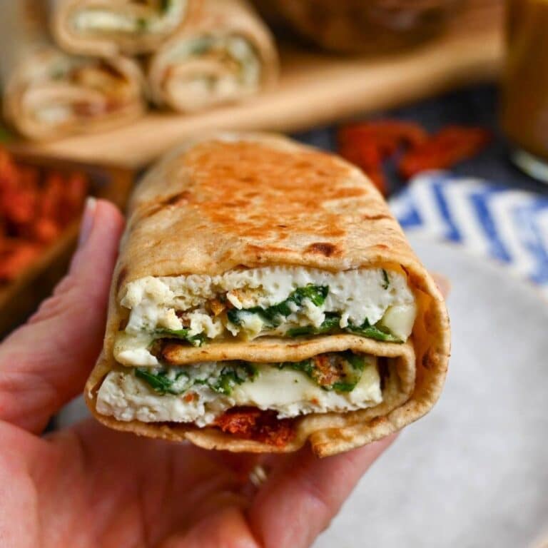 holding up a homemade copycat Spinach feta egg wrap
