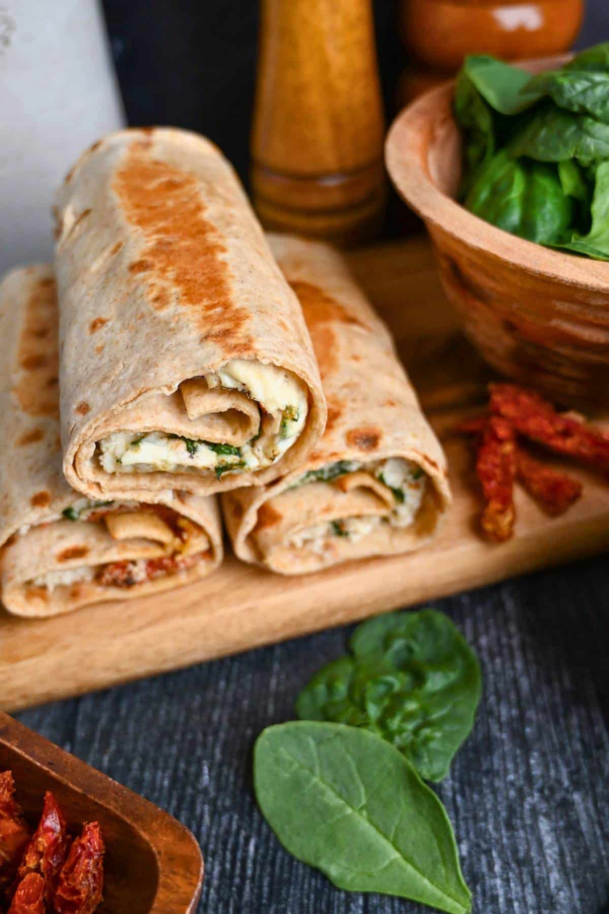 toasted spinach feta egg wraps on a cutting board