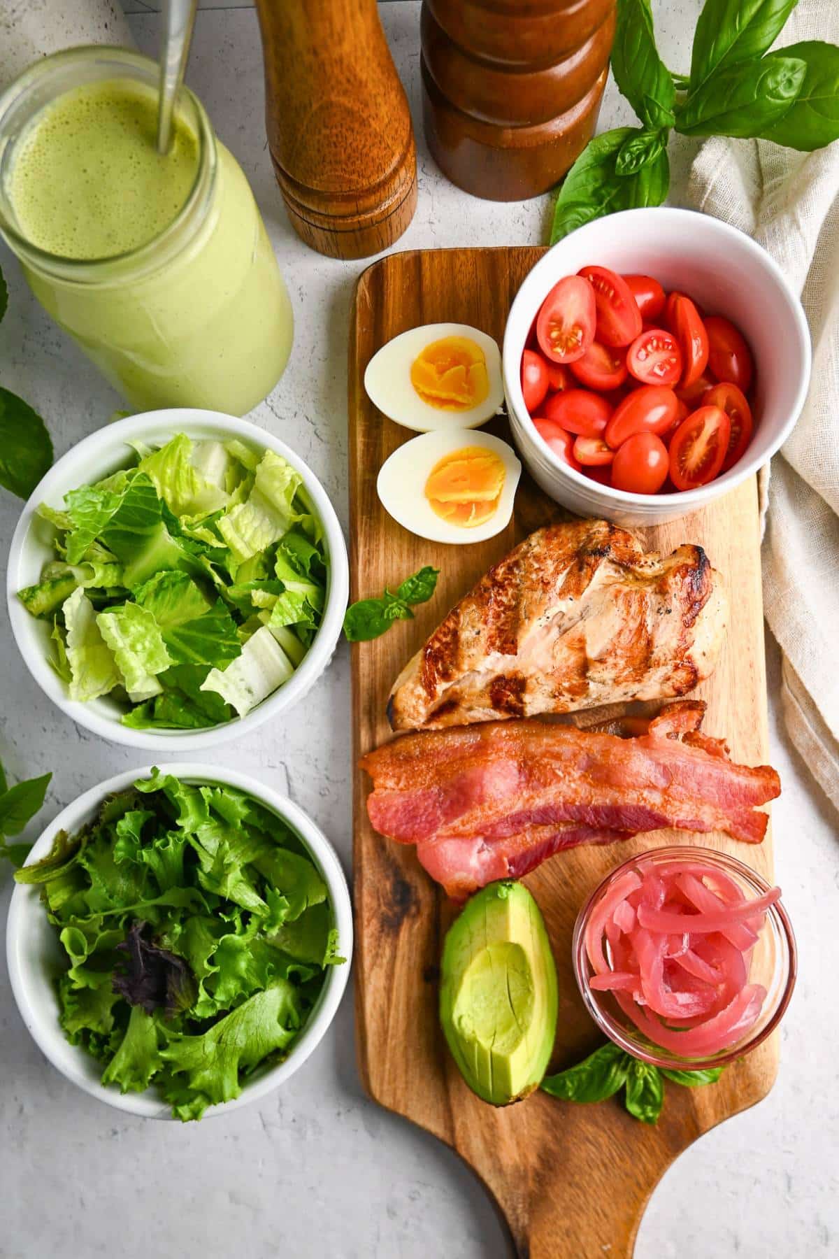 ingredients for a grilled chicken cobb with green goddess dressing on a counter