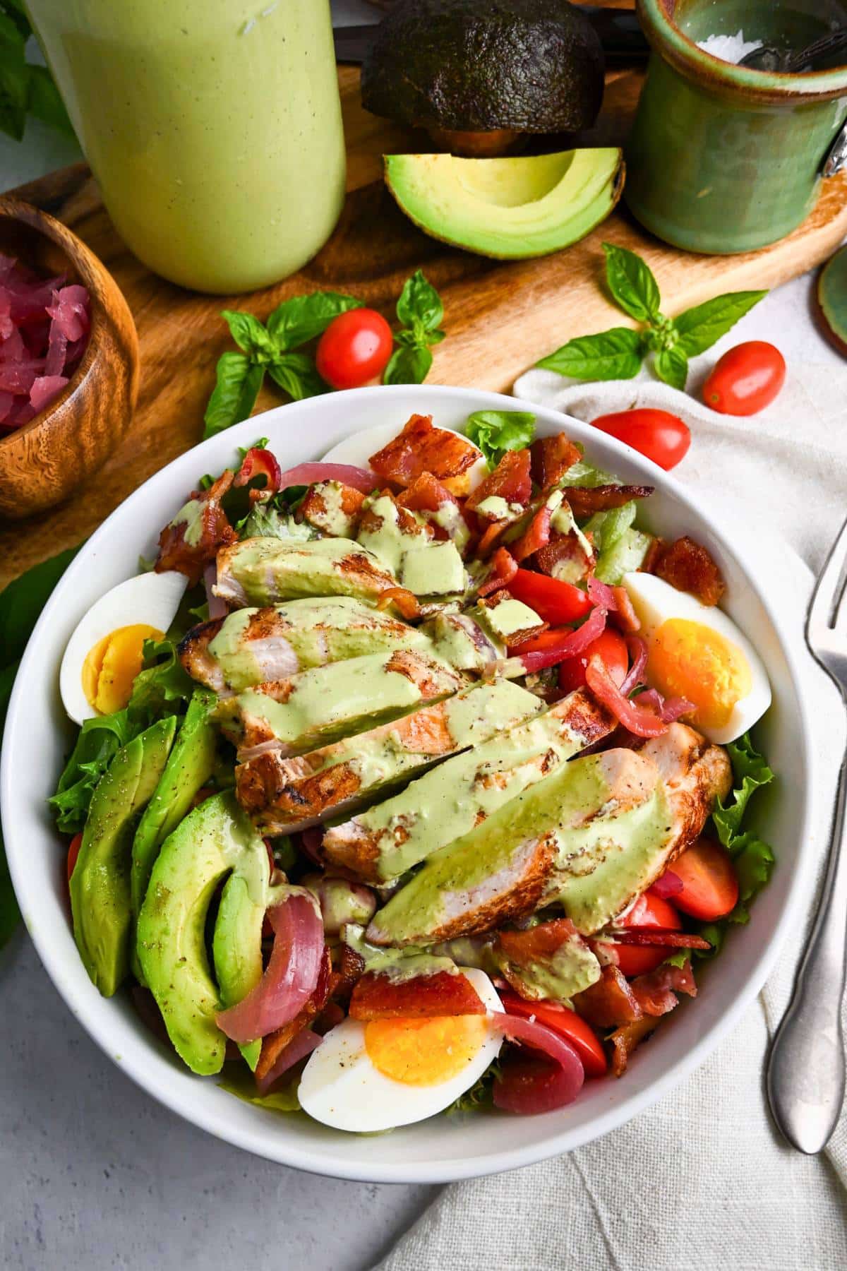a green goddess grilled chicken salad with a fork and napkin