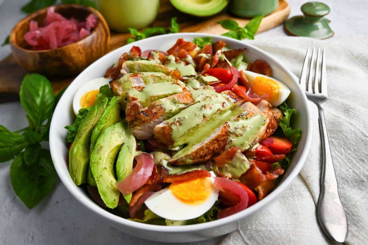 a green goddess chicken cobb salad with a napkin and fork